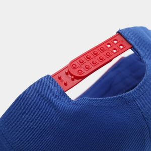 Dettaglio della chiusura snapback rossa sul cappellino hip hop in tela blu bicolore