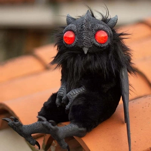 Λεπτομερής όψη της κούκλας μωρό Mothman με βελούδινη γούνα και μεγάλα κόκκινα μάτια στη στέγη