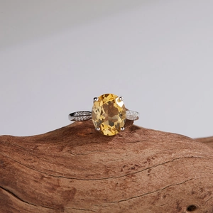 Macro shot of S925 silver ring with natural citrine stone on a wooden surface