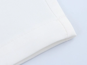 Macro detail of the double-stitched hem and fabric texture of the white canvas set