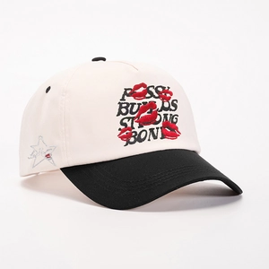 Two-tone baseball cap in cream and black with embroidered lips and letter branding