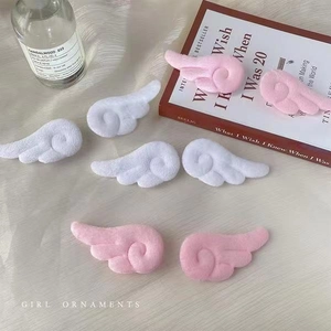 Detail von flauschigen Engelsflügel-Haarclips in Rosa und Weiß mit weicher Textur
