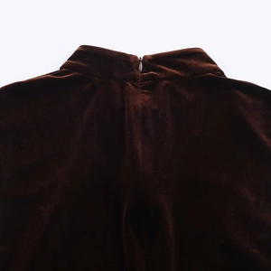 Détail de la fermeture éclair invisible sur une robe en velours marron avec dentelle