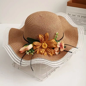 Women's wide brim straw sun hat with sunflower accent and lace trim for beach trips