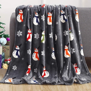 Detailed texture of flannel Christmas blanket featuring snowmen on a cozy sofa