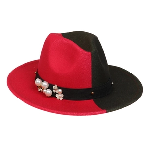 Detail of red and black felt fedora featuring white pearl and floral embellishments