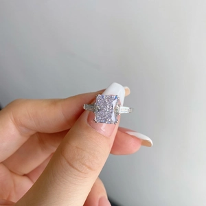 Macro shot of an S925 silver ring featuring a rectangular radiant cut purple gemstone