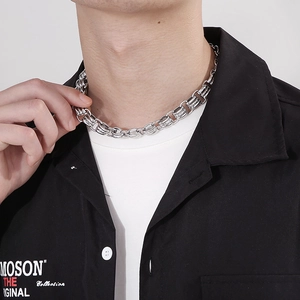 Close-up of 15mm chunky stainless steel chain necklace worn by a model on a black shirt