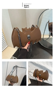 Close-up of brown bat-shaped jelly bag with metallic skull and fine chain strap