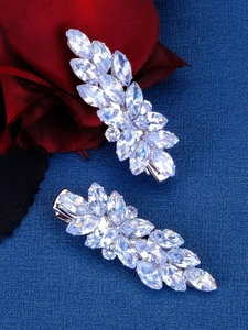 Close-up of sparkling crystal zircon bow hair clips with silver metallic leaf patterns