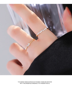 Detail showing two gold-finish heart rings on hand with twisted band and cubic zirconia