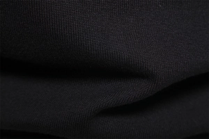 Macro shot of high-quality black knit fabric texture showing fine weave and soft material