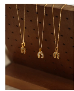 Gros plan de colliers à pendentif fer à cheval plaqués or 18 carats avec diamants