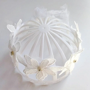 Dettaglio della corona di fiori in pizzo bianco per neonata con strass scintillanti