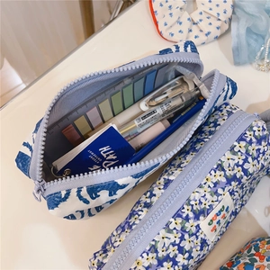 Detail view of large capacity floral and dinosaur pencil cases with stationery