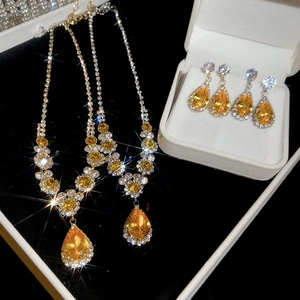Macro shot of pear-shaped yellow zircon necklaces and earrings in a luxury jewelry box