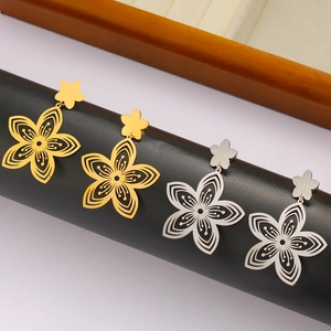 Detail view of hollow flower earrings in gold and silver finish on a display stand