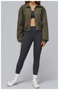 Detail of army green windproof jacket with high-waist yoga pants and white sneakers