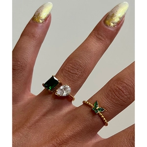 Detail of 18k gold plated titanium ring set with green emerald and drop zircon
