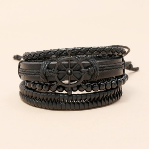 Detailed macro view of 4-piece black leather bracelet set with woven rope and rudder charm