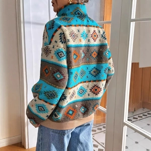 Dettaglio del pullover in pile con motivi etnici geometrici e bordo inferiore a coste