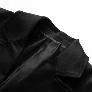 Detail shot of black slim-fit blazer showing padded shoulders and lapel stitching