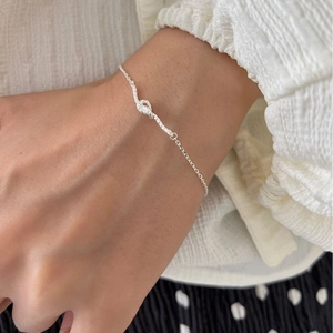 Elegant S925 sterling silver knotted heart bracelet worn on a model's wrist