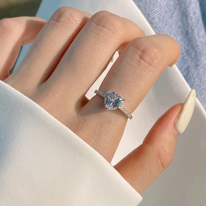 Close-up of S925 sterling silver heart diamond ring worn on a finger for proposal