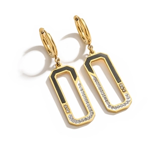 Macro view of gold rectangular dangle earrings with black inlay and sparkling zircons