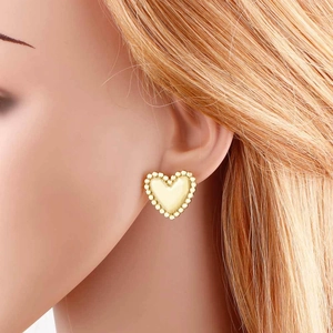 Sweet heart shaped earrings with beaded metal edges in pale yellow finish on model