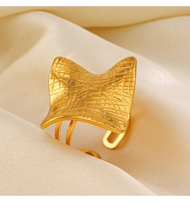 Detailed macro view of a gold square ring with grid texture on silk fabric