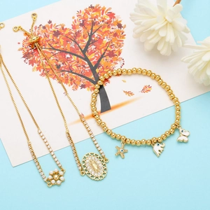 Detail of gold charms including a starfish, white elephant, and butterfly on a beaded bracelet