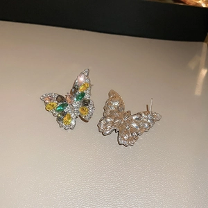 Detailed macro view of butterfly earrings with multi-colored teardrop crystals and silver studs