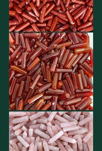 Macro shot of bulk natural rose quartz and red jasper hexagonal healing crystal pillars