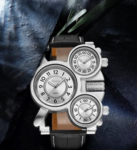 Close-up of dual-time silver military watch with black leather strap on blue rock