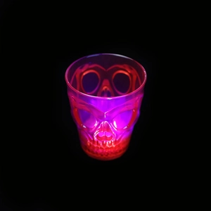 Macro view of glowing skull shot glass with purple and red LED lighting for parties