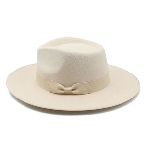 Detail of a creamy white wool felt hat with a flat top, wide brim and a matching bow ribbon