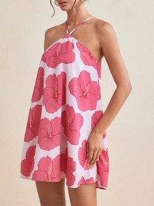 Detail of a white halter dress with pink floral prints and a flowing A-line silhouette