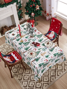 Close-up of festive polyester tablecloth with Christmas trees and Santa Claus chair covers