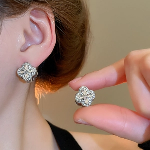 Detail of silver-tone clover earrings with sparkling pavé crystals and marquise petals