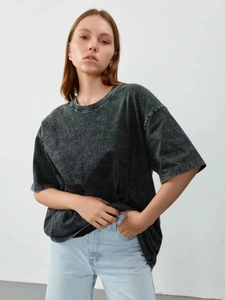 Detail shot of the vintage washed acid black cotton fabric on a loose fit t-shirt