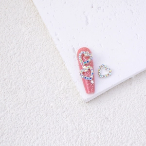 Detail of pink glitter nails with heart rhinestone alloy charms for Valentine's nail art