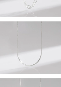 Detailed view of silver heart-shaped links and sleek snake chain necklace textures