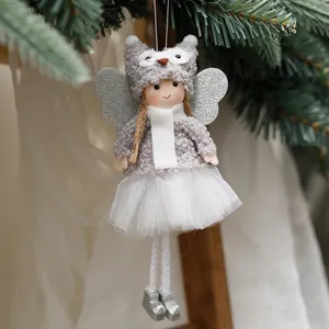 Plush Christmas angel doll ornament with silver wings hanging on a green tree branch