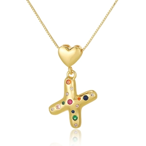 Macro shot of gold necklace with letter X pendant and colorful cubic zirconia
