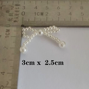 Detailed view of a white pearl bow accessory measuring 3cm x 2.5cm for DIY crafts