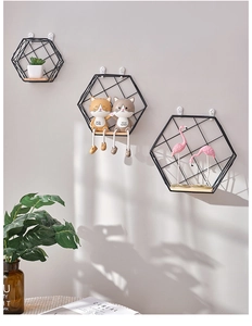 Close-up of three hexagonal metal wall shelves with wooden bases and black mesh grid