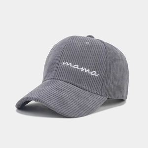 Close-up of gray corduroy baseball cap with white mama embroidery and ribbed texture
