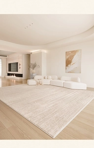 Detalle de alfombra beige texturizada con patrones lineales en un salón moderno y elegante