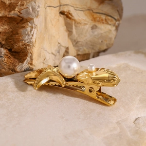 Golden starfish and seashell hair clip with pearls on natural stone background